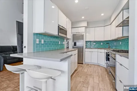 a kitchen with stainless steel appliances kitchen island granite countertop a stove a sink and a refrigerator