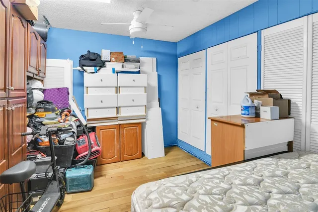 a bedroom with bed and wooden cabinets