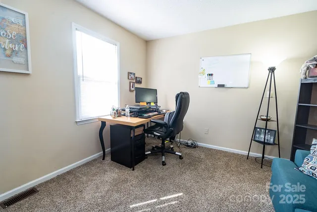 a view of a workspace with furniture and a window