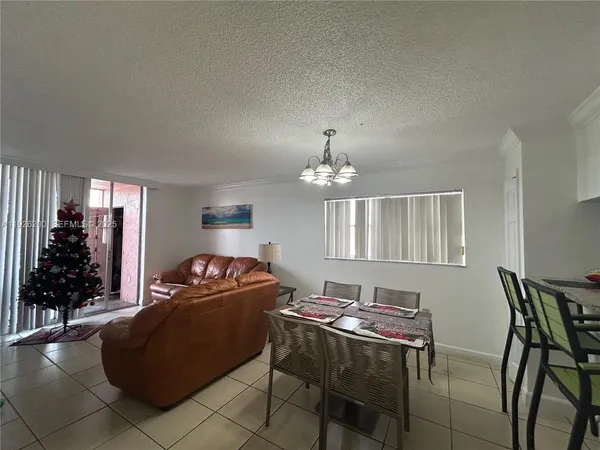 a living room with furniture a chandelier and a window