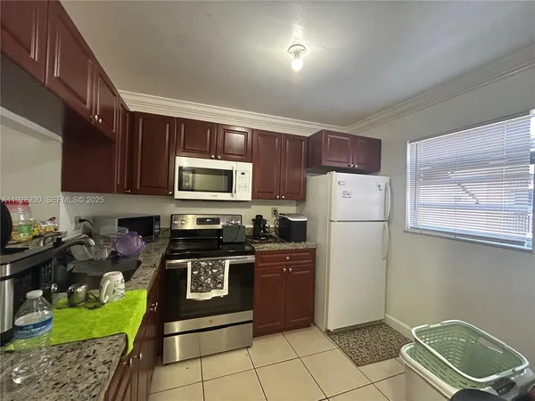 a kitchen with a refrigerator a stove a microwave and cabinets