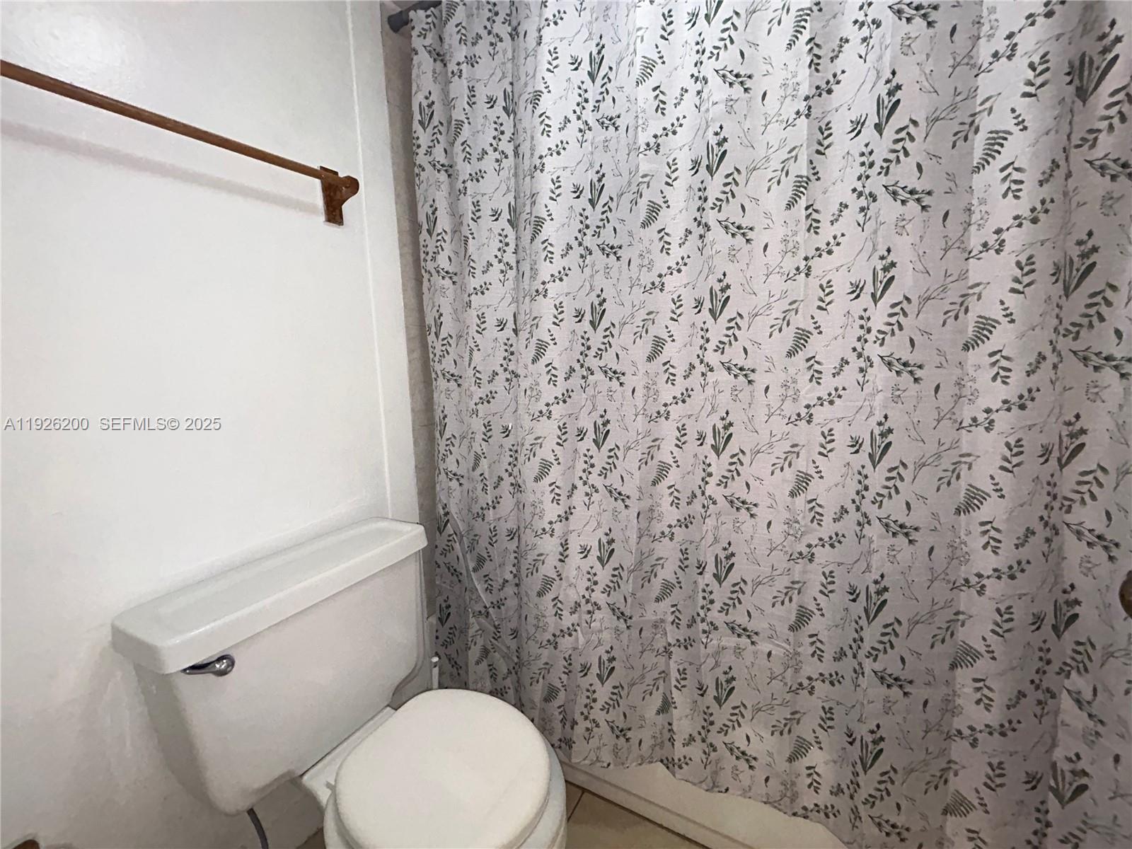 19805 Southwest 114th Avenue, Unit 219 Miami, FL 33157 - Photo 8 of 12 a white toilet sitting next to a shower curtain