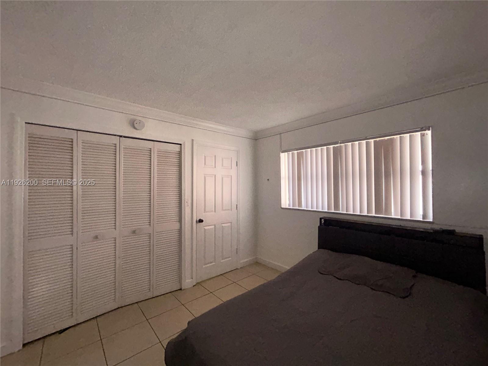 19805 Southwest 114th Avenue, Unit 219 Miami, FL 33157 - Photo 10 of 12 a bedroom with a bed and a window