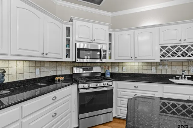 a kitchen with granite countertop white cabinets and appliances