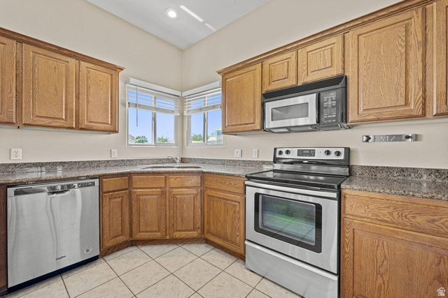 2226 East 140 South St. George, UT 84790 - Photo 8 of 20 Kitchen featuring wood cabinetry, stainless steel appliances, granite-style countertops, and a tile floor