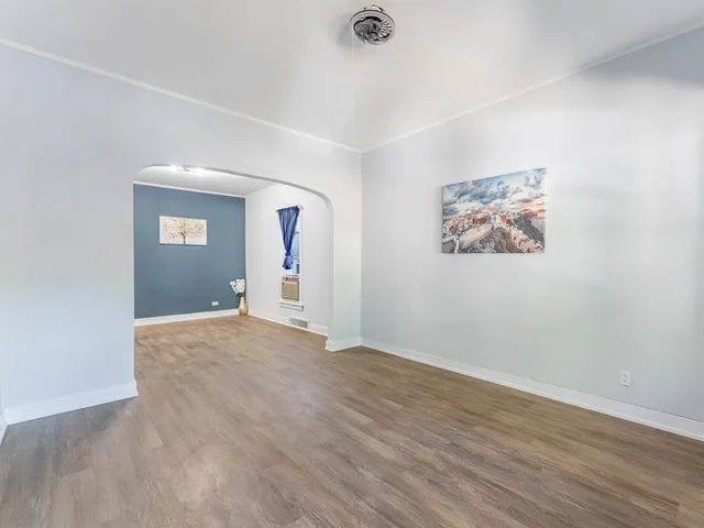an empty room with wooden floor and window