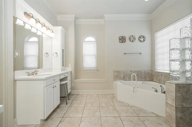 a spacious bathroom with a tub sink and mirror
