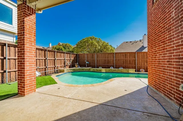 a view of a backyard with plants and wooden fence