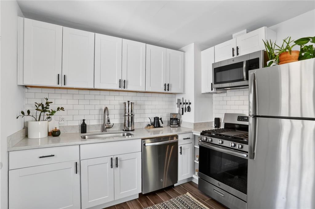 1267 Lyle Place Northwest Atlanta, GA 30318 - Photo 6 of 15 a kitchen with stainless steel appliances a stove a sink a refrigerator and cabinets