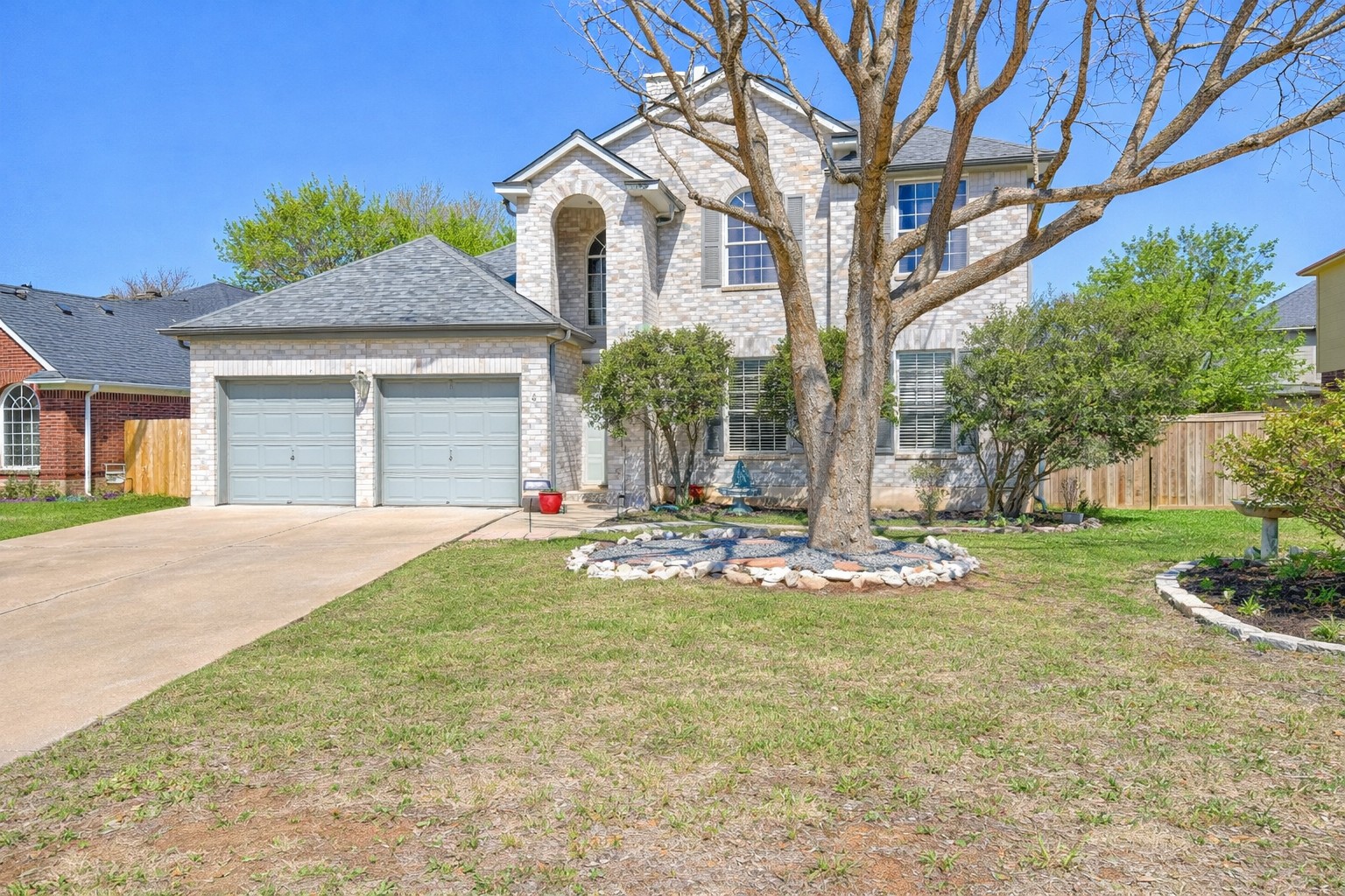 View of front of home featuring an attached garage, brick siding, and concrete driveway