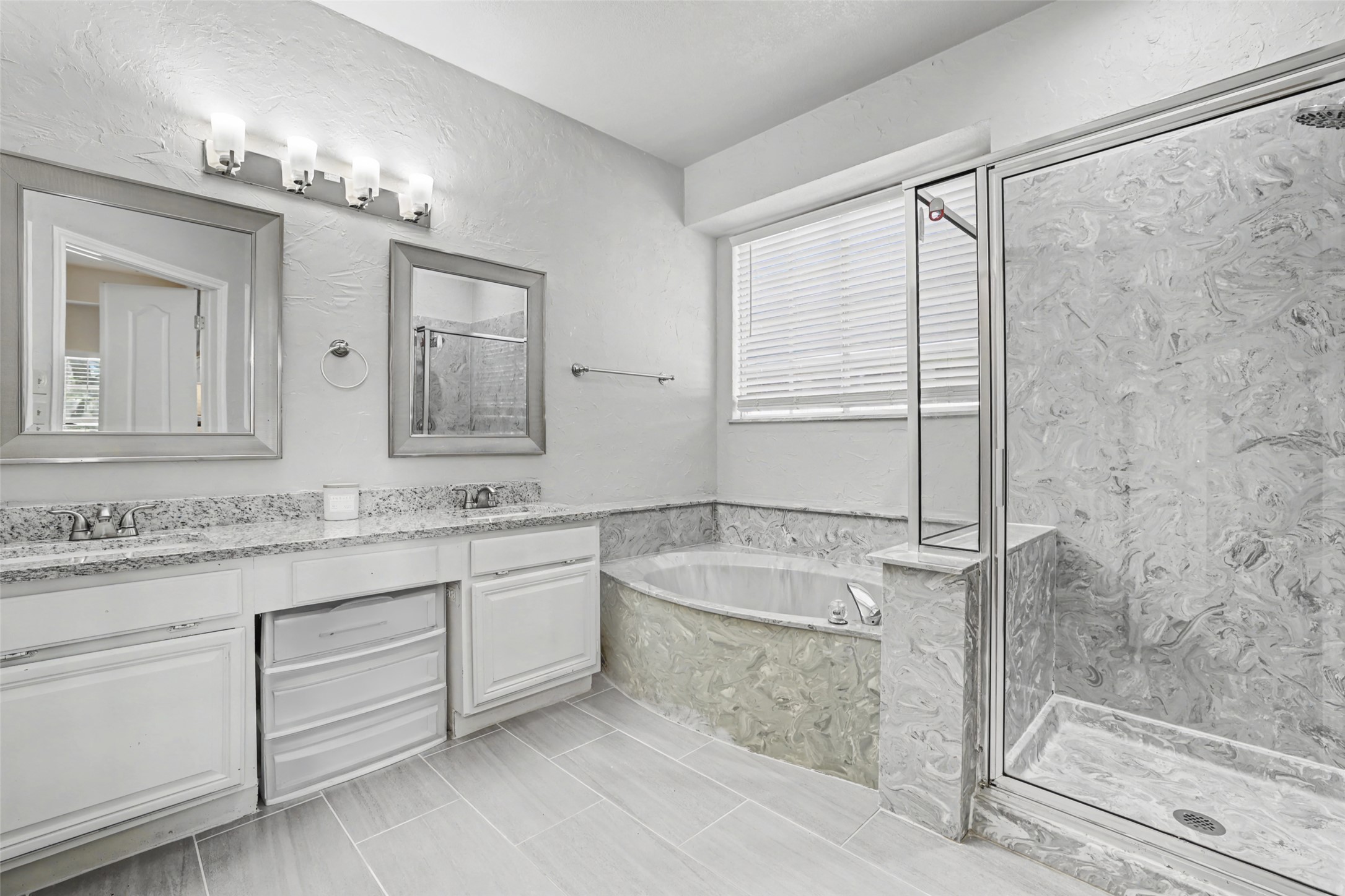 1109 Pebble Brook Road Cedar Park, TX 78613 - Photo 20 of 40 Full bathroom featuring a marble finish shower, double vanity, a garden tub, a textured wall, and light tile patterned floors