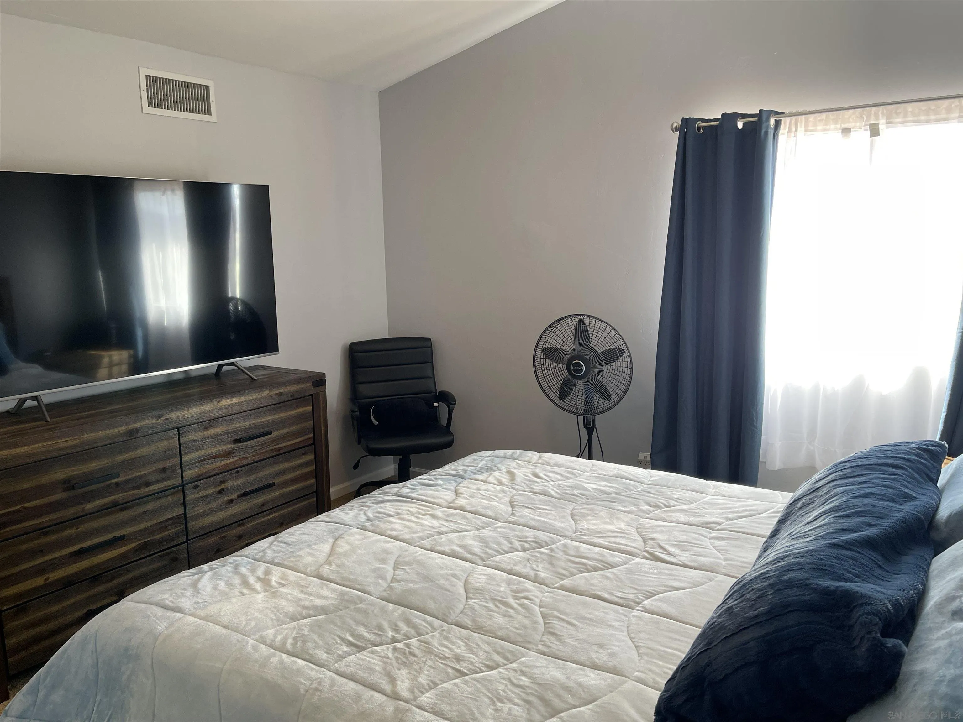 10306 Leila Lane Santee, CA 92071 - Photo 21 of 31 a bedroom with a bed and a flat tv screen on dresser