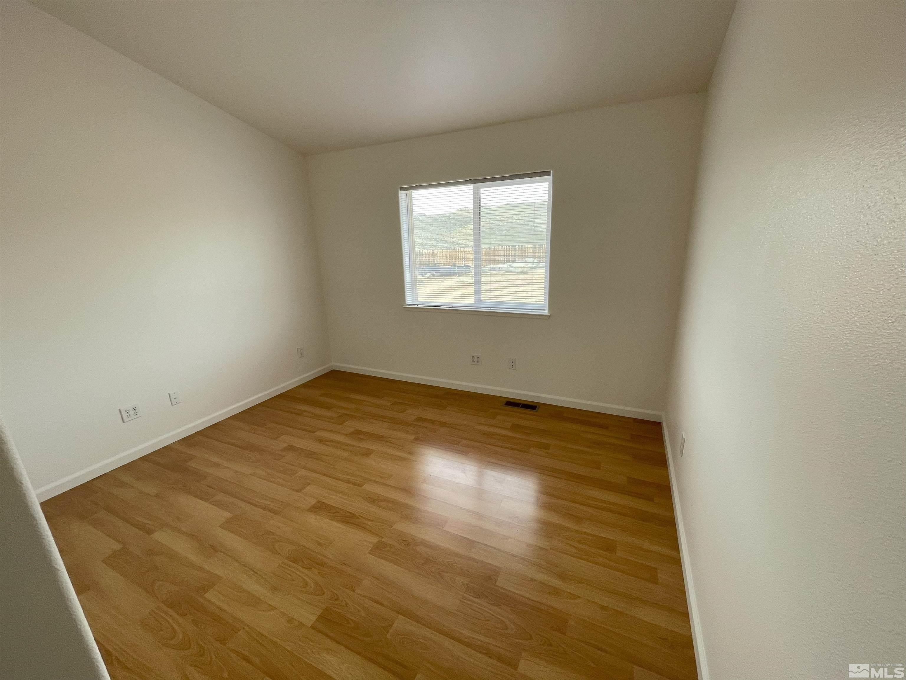 15064 North Red Rock Road Reno, NV 89508 - Photo 13 of 40 an empty room with wooden floor and windows