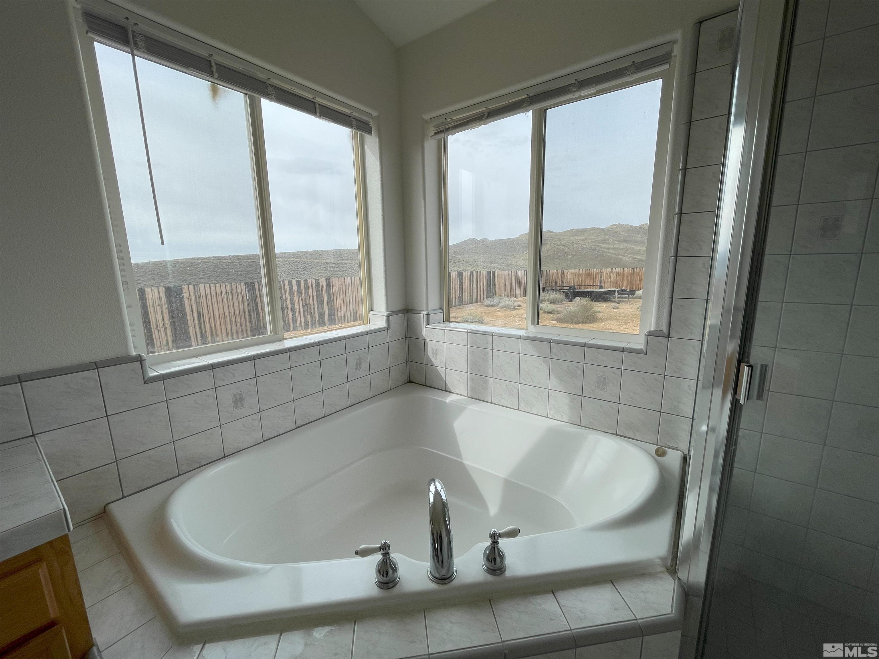 15064 North Red Rock Road Reno, NV 89508 - Photo 8 of 40 a bath tub sitting in a bathroom next to a window