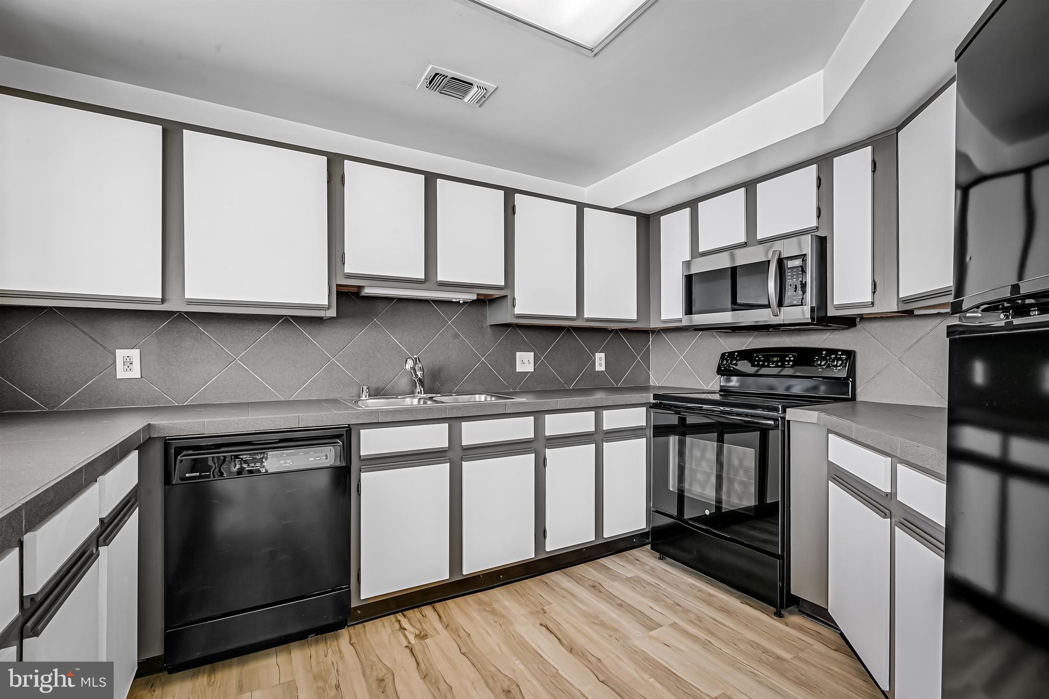 960 Fell Street, Unit 311 Baltimore, MD 21231 - Photo 11 of 59 a kitchen with stainless steel appliances granite countertop a stove a sink and a microwave