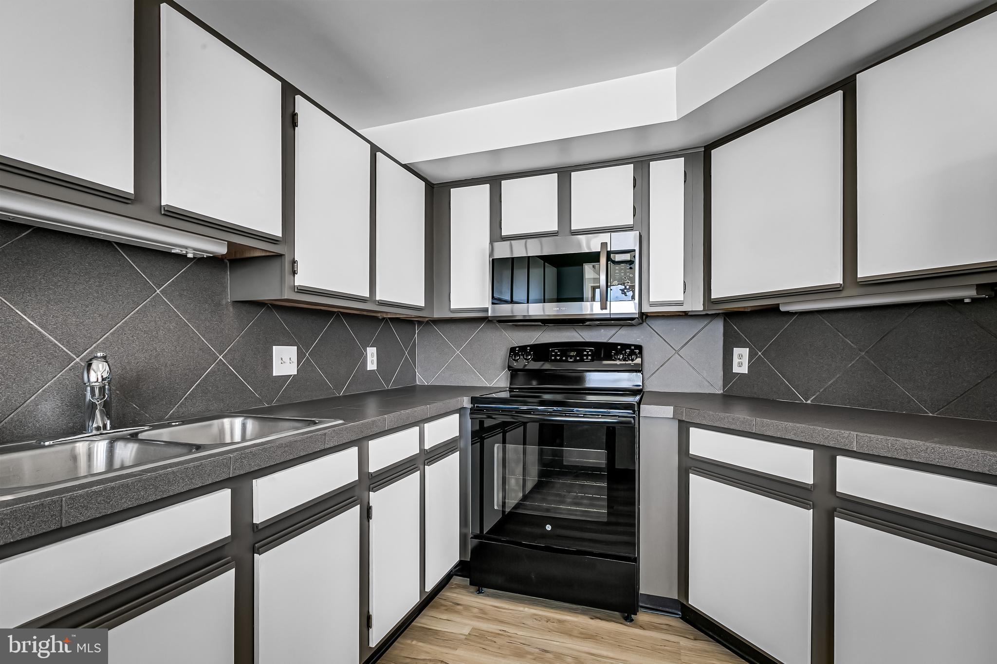 960 Fell Street, Unit 311 Baltimore, MD 21231 - Photo 13 of 59 a kitchen with stainless steel appliances granite countertop a stove and a sink