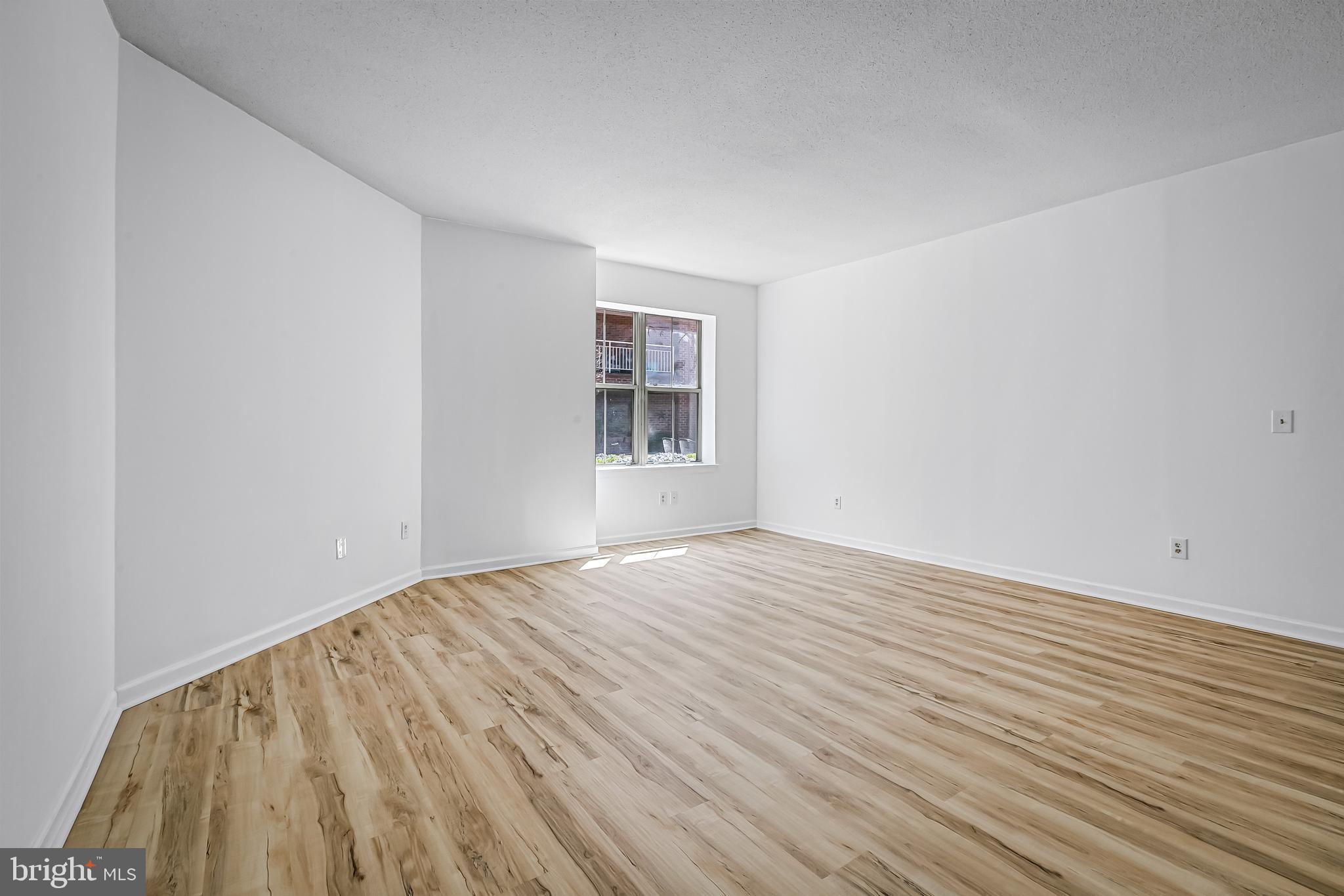 960 Fell Street, Unit 311 Baltimore, MD 21231 - Photo 22 of 59 a view of an empty room with wooden floor and a window