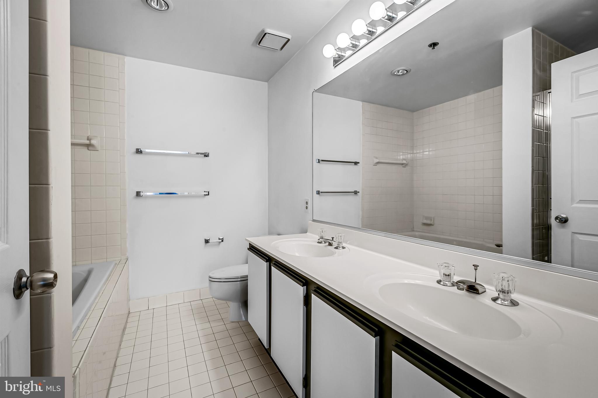 960 Fell Street, Unit 311 Baltimore, MD 21231 - Photo 25 of 59 a spacious bathroom with a double vanity sink toilet and shower