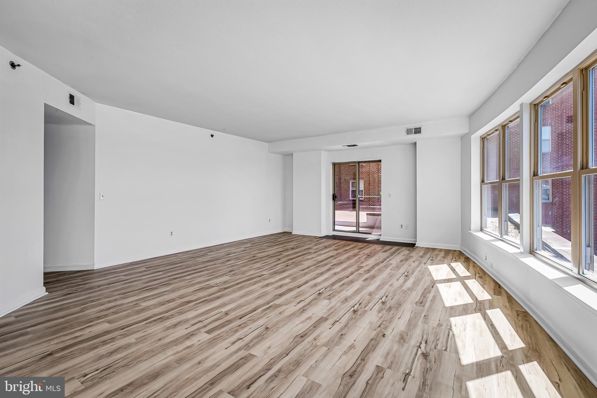 960 Fell Street, Unit 311 Baltimore, MD 21231 - Photo 8 of 59 a view of an empty room with wooden floor and a window