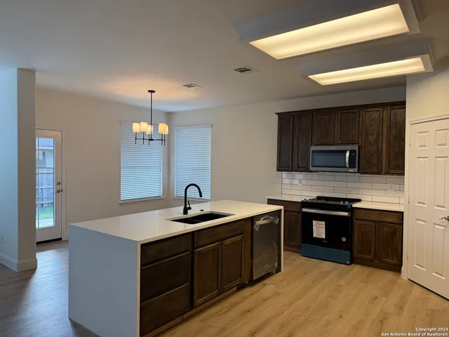 a kitchen with stainless steel appliances granite countertop a sink and a stove