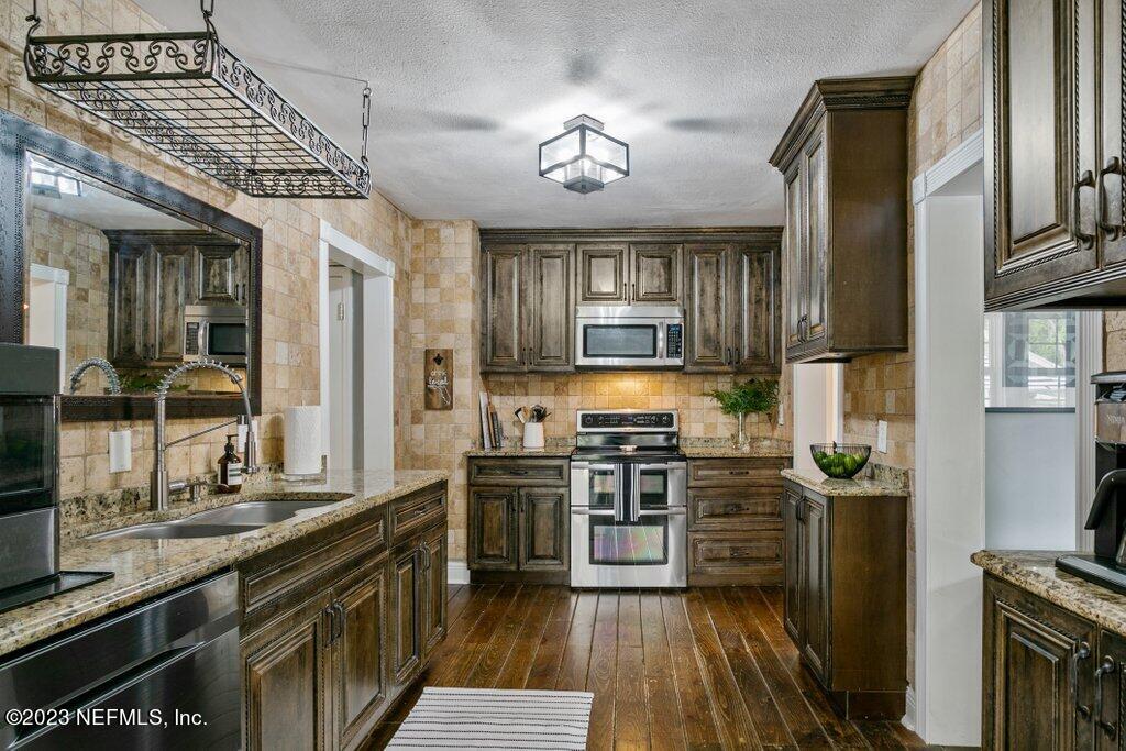 1623 Charon Road Jacksonville, FL 32205 - Photo 12 of 45 a kitchen with stainless steel appliances granite countertop a stove refrigerator and cabinets