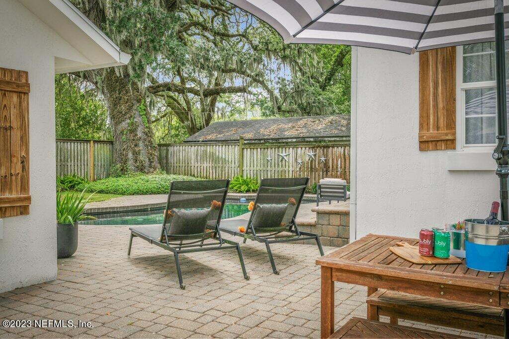 1623 Charon Road Jacksonville, FL 32205 - Photo 19 of 45 a view of a patio with table and chairs potted plants with wooden floor and fence