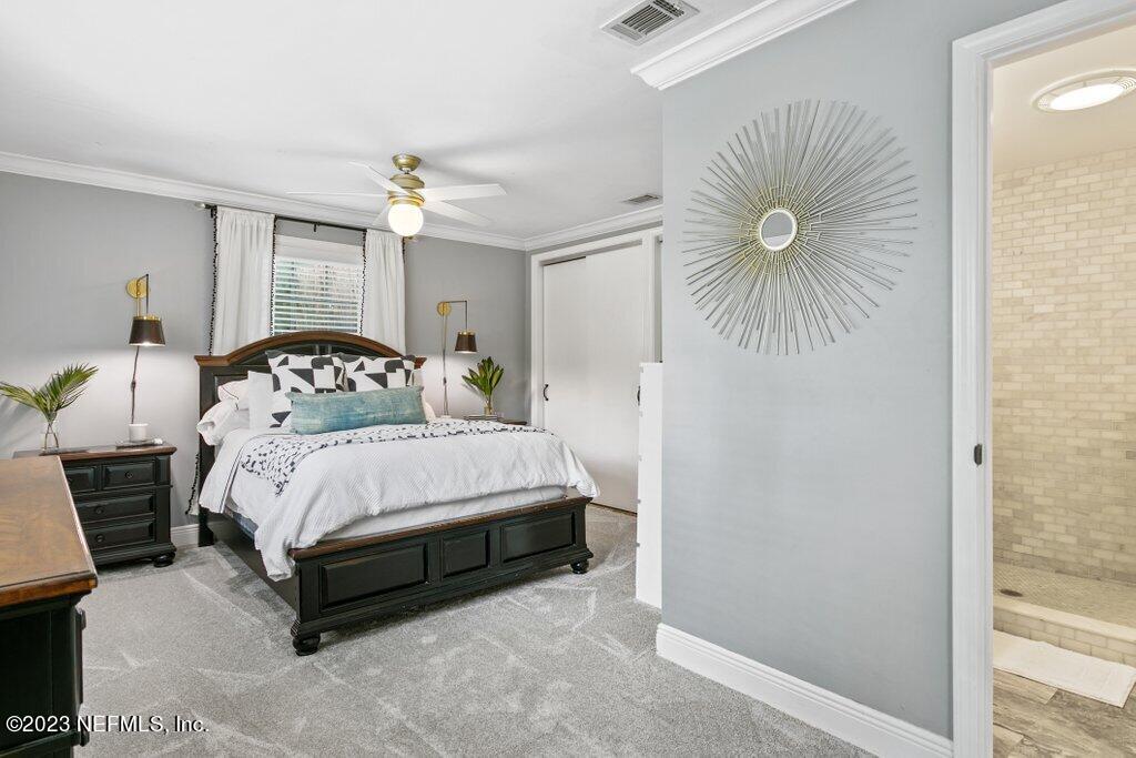 1623 Charon Road Jacksonville, FL 32205 - Photo 30 of 45 a bedroom with a bed and a chandelier