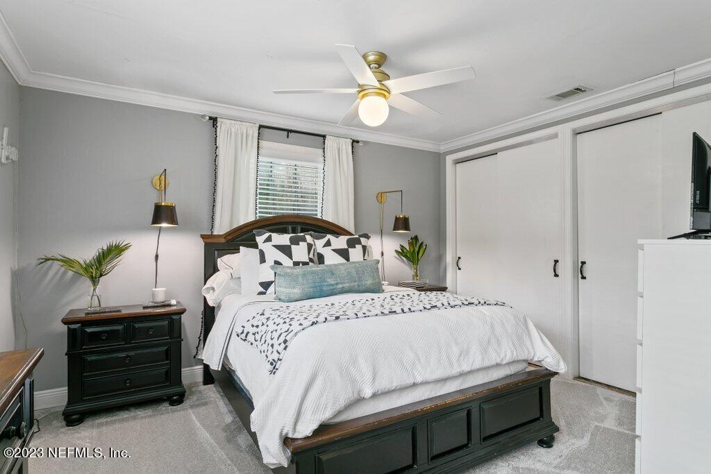 1623 Charon Road Jacksonville, FL 32205 - Photo 31 of 45 a bedroom with a bed a chandelier and a window