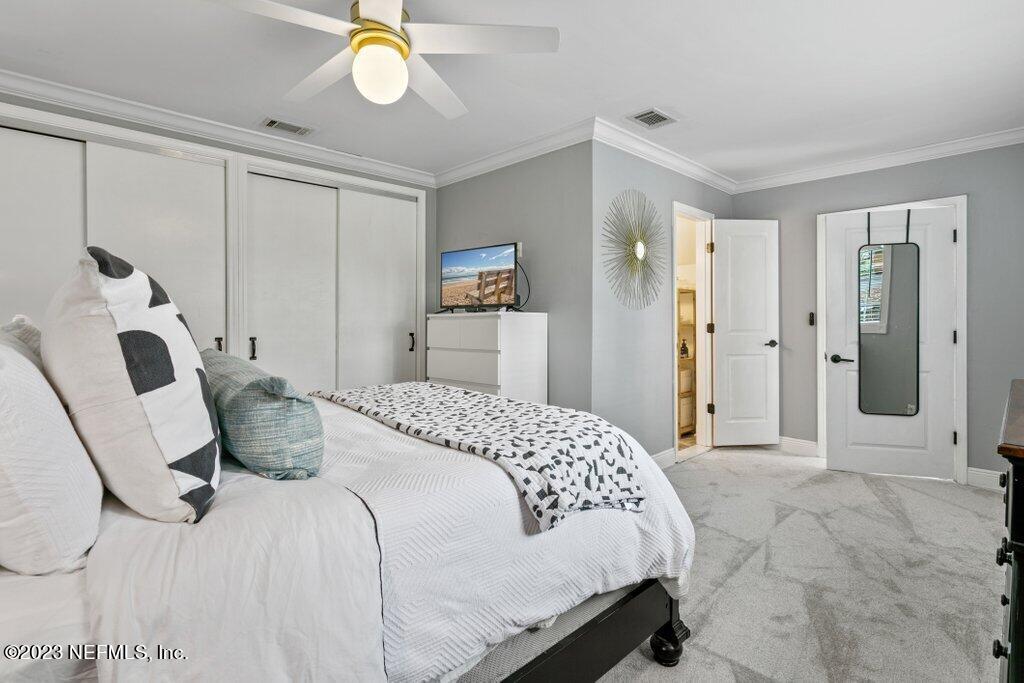 1623 Charon Road Jacksonville, FL 32205 - Photo 32 of 45 a bedroom with a bed and a chandelier