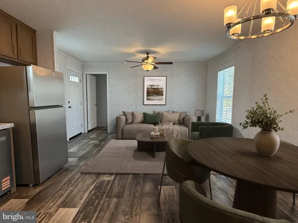 a living room with furniture potted plant and kitchen view