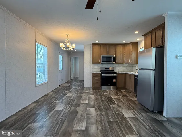 a large kitchen with kitchen island a large counter space stainless steel appliances and cabinets