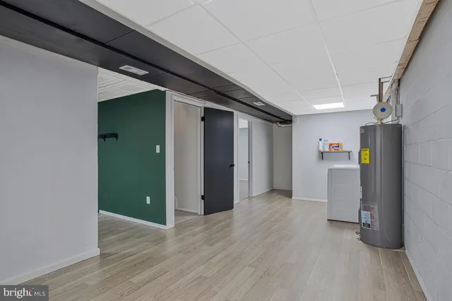 a view of an empty room with wooden floor and stairs