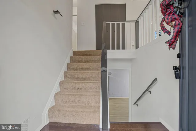 a view of staircase with lots of frames on wall and wooden floor
