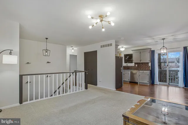 a view of a living room and kitchen with a sink