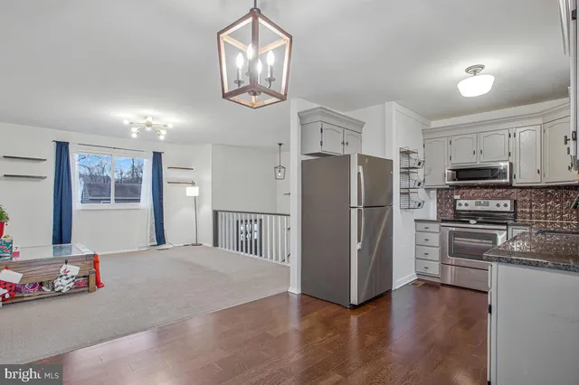 a kitchen with stainless steel appliances a refrigerator and a stove top oven