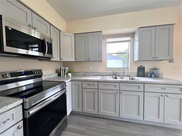 a kitchen with white cabinets and stainless steel appliances