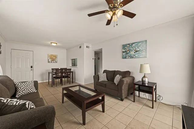 a living room with furniture and a ceiling fan