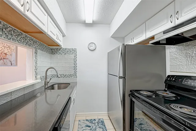 a kitchen with stainless steel appliances granite countertop a sink and a refrigerator