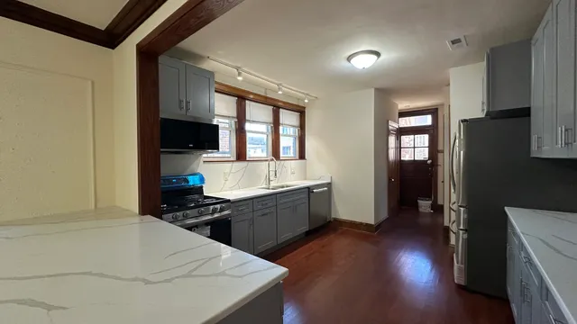 a kitchen with a sink a counter top space and stainless steel appliances