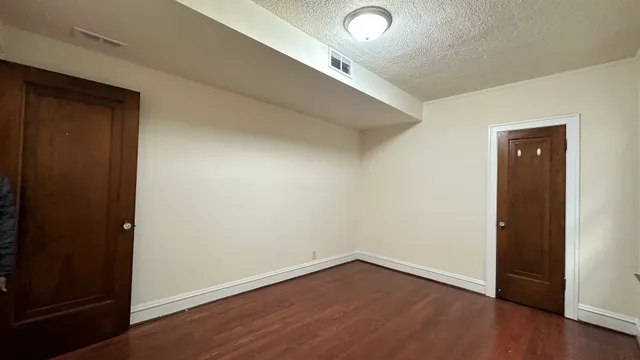 an empty room with wooden floor and closet