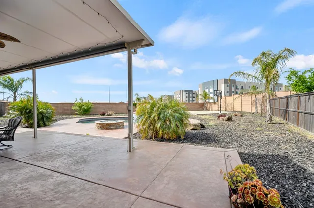 a view of a patio with table and chairs under an umbrella