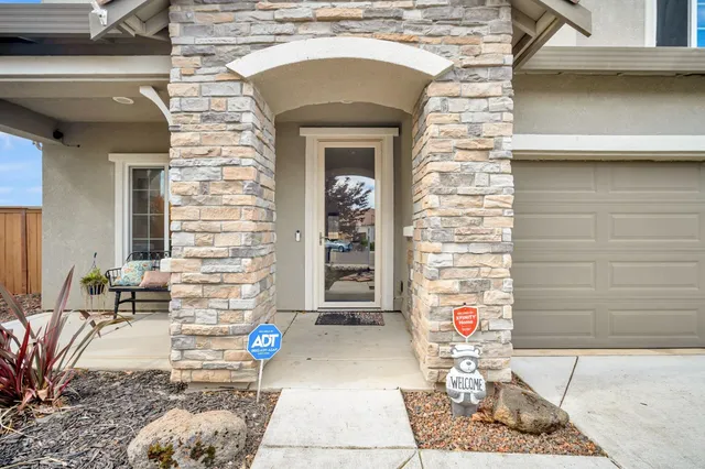 a kitchen with stainless steel appliances kitchen island granite countertop a sink refrigerator and cabinets