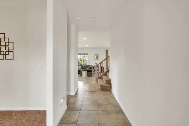 a kitchen with stainless steel appliances granite countertop a refrigerator a sink dishwasher a stove top oven a kitchen island and chairs