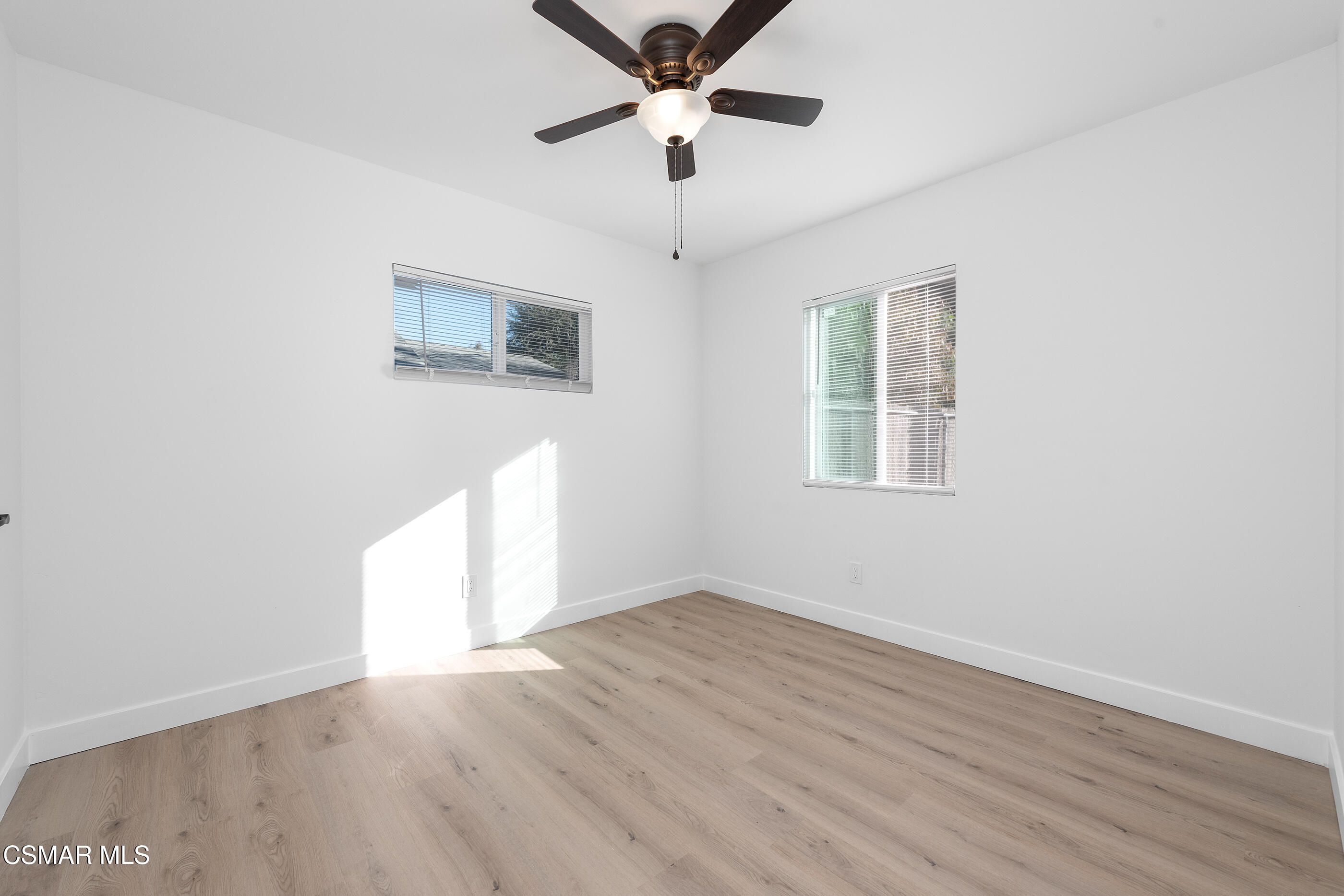 3942 Hitch Boulevard Moorpark, CA 93021 - Photo 10 of 42 an empty room with wooden floor ceiling fan and windows