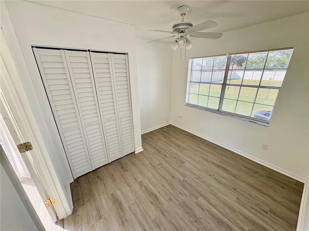 5389 Mariner Boulevard Spring Hill, FL 34609 - Photo 13 of 17 an empty room with wooden floor fan and windows