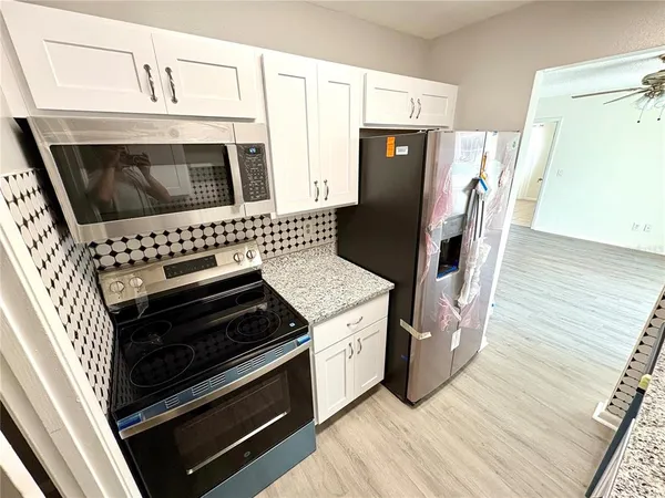 a kitchen with appliances and wooden floor