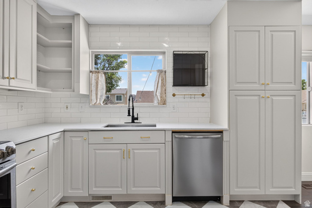 2223 North Pointe Meadow Loop Lehi, UT 84048 - Photo 15 of 56 Kitchen featuring light cabinetry with gold hardware, white subway tile backsplash, stainless steel dishwasher, and a deep basin sink with a black faucet