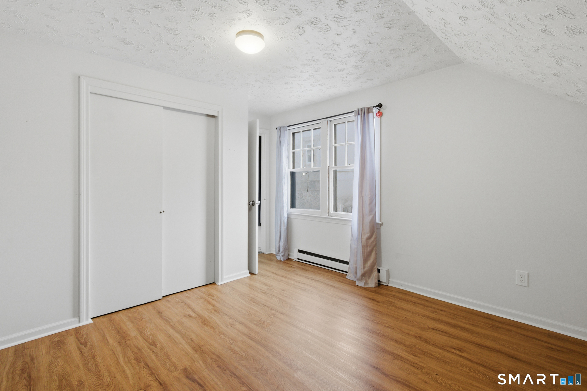 590 North Walnut Street Waterbury, CT 06704 - Photo 17 of 37 an empty room with wooden floor and windows