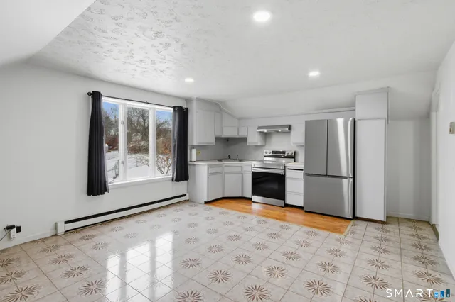 a kitchen with a refrigerator and a stove top oven