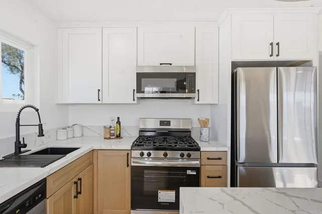 a kitchen with cabinets stainless steel appliances and a sink